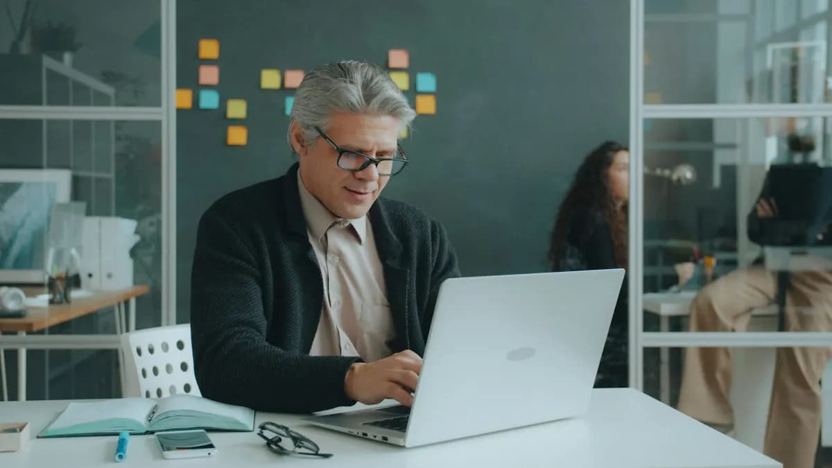 A mature professional learning on a laptop at a desk