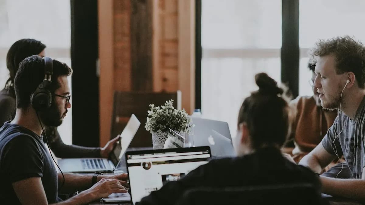 Young marketing team working on laptops together around a table in an office