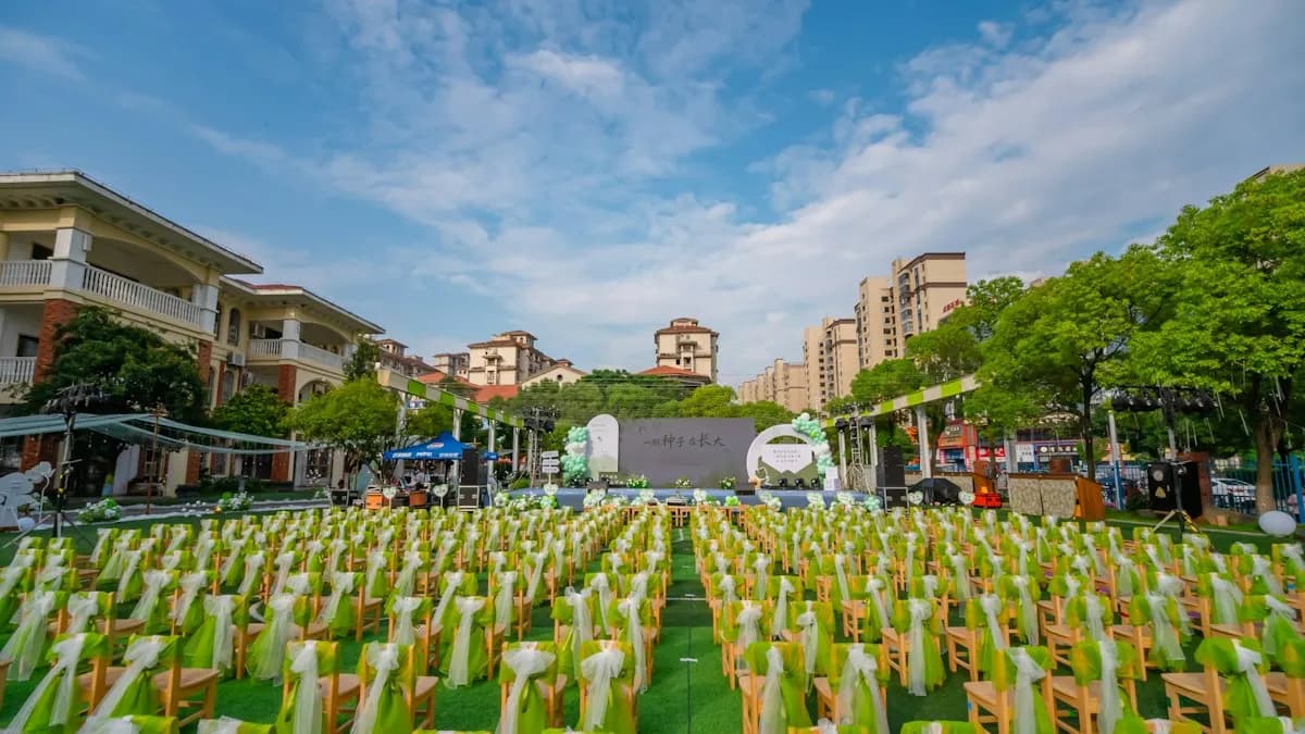 Rows of decorated chairs on a lawn facing an outdoor event stage