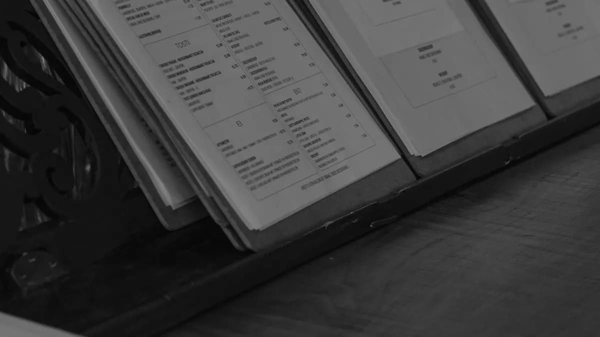 Three restaurant menus on wooden clipboards standing on a counter