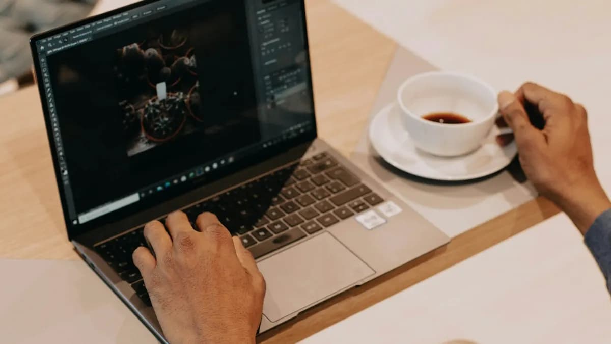 Person working on a laptop beside a cup of coffee while learning digital marketing