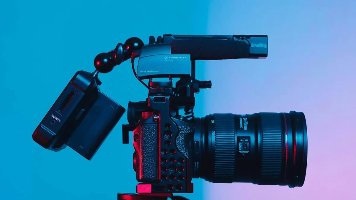 Video camera with a zoom lens and microphone on a tripod ready to shoot a YouTube video