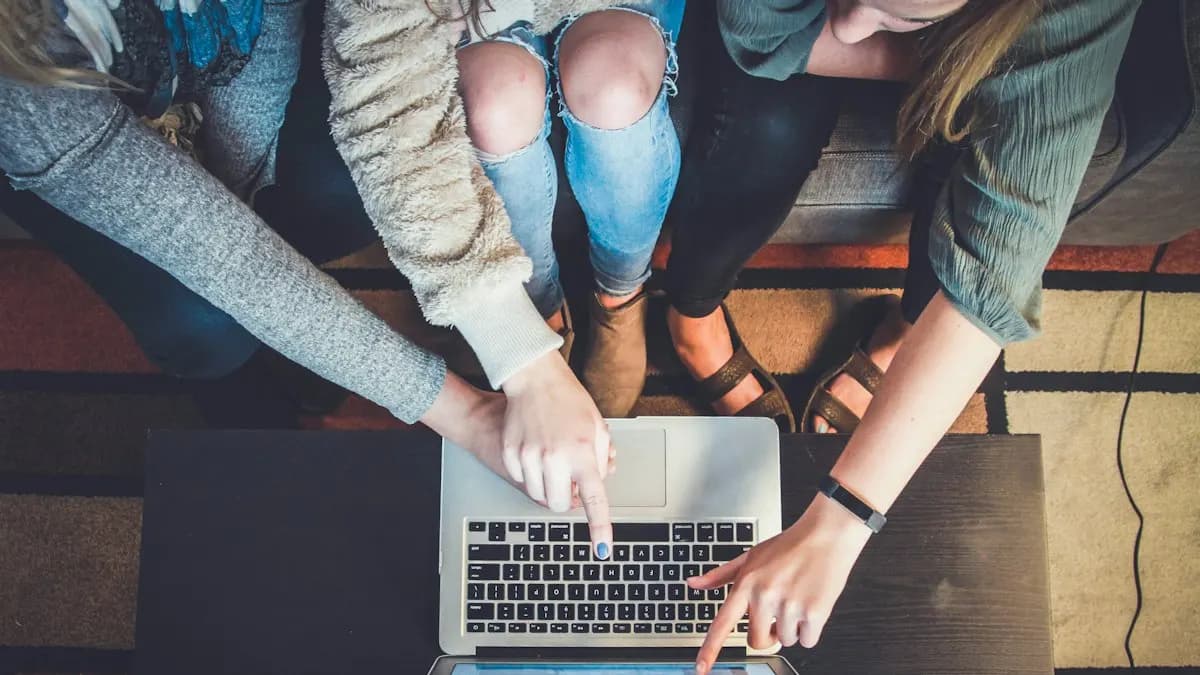 Three marketing students pointing at a laptop while planning a performance marketing campaign