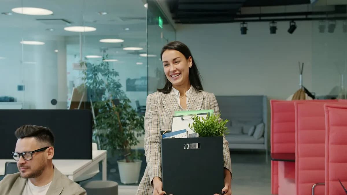 Smiling woman leaving an office with a box of her things, starting a career change