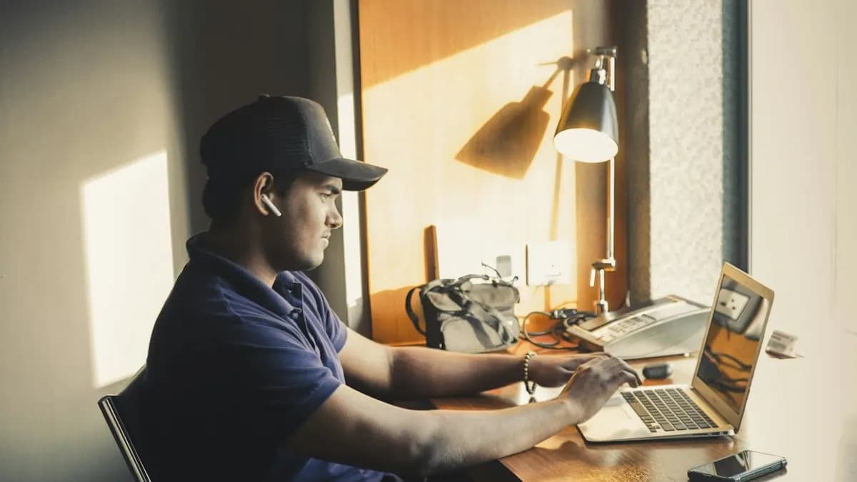 Young freelancer working on a laptop at a sunlit home desk