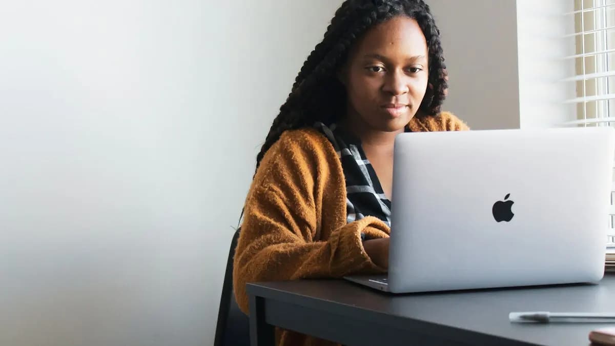Commerce student working on a laptop at a desk while learning graphic design