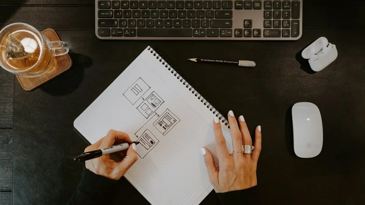 Designer sketching layout ideas on paper beside a computer keyboard