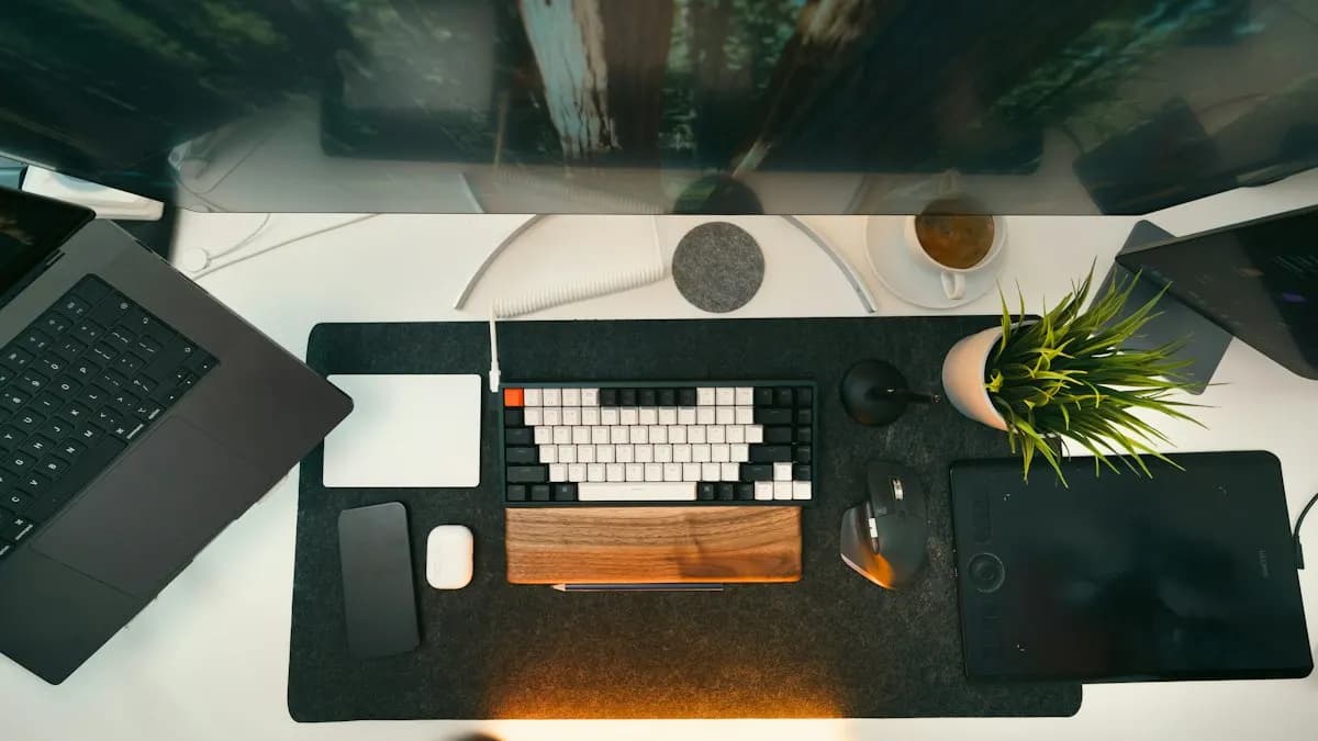Top view of a motion designer's desk with a monitor, mechanical keyboard, pen tablet and laptop