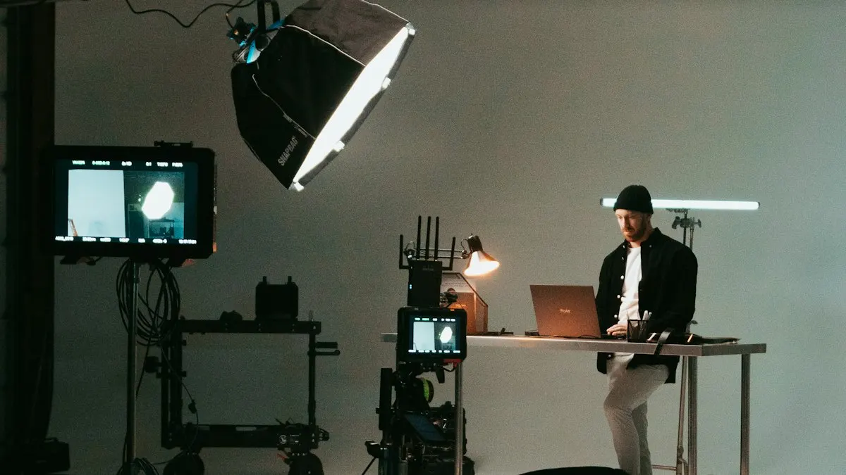 Video editor working on a laptop in a film studio with lights and camera monitors around him