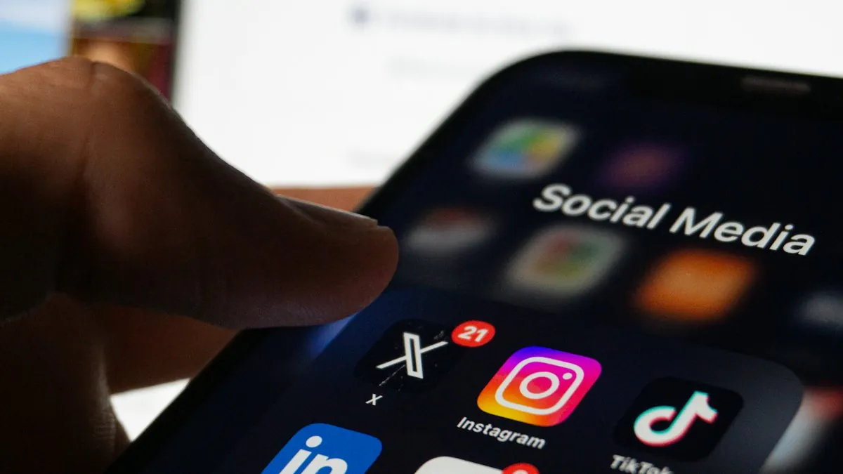 A hand holding a smartphone showing social media app icons