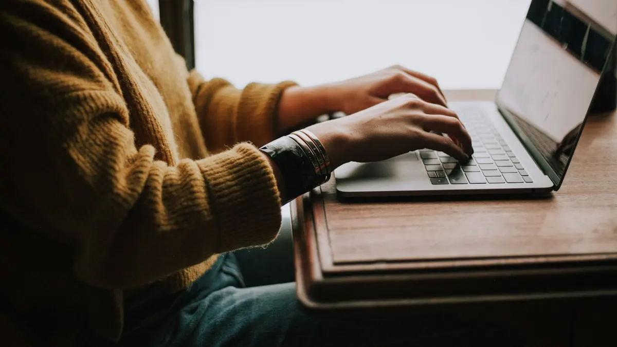 Learner typing on a laptop at a wooden desk during an online digital marketing class