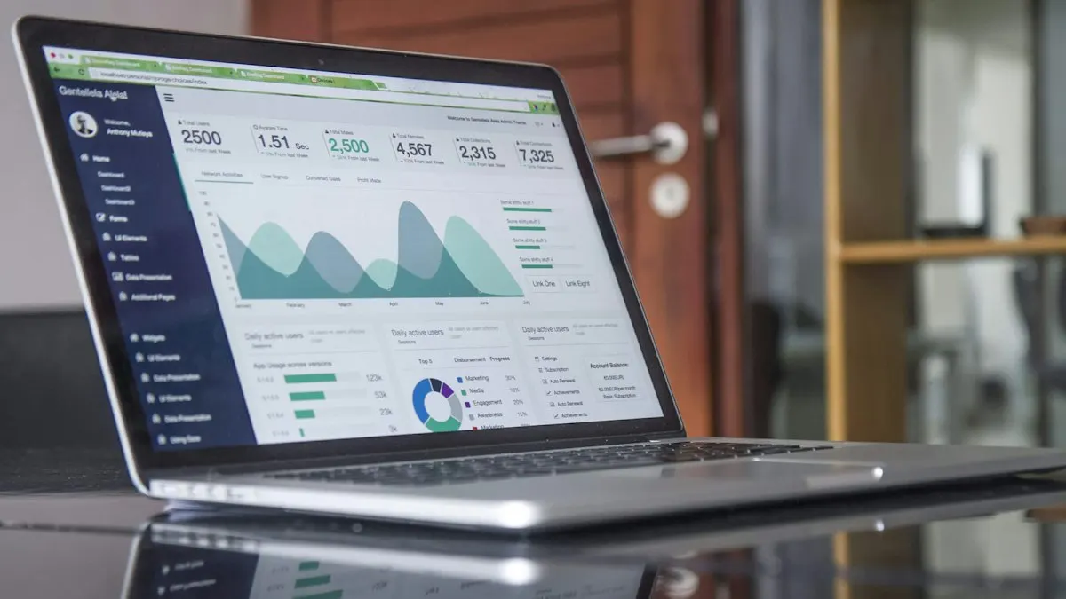 Laptop on a glass table showing a marketing analytics dashboard with charts