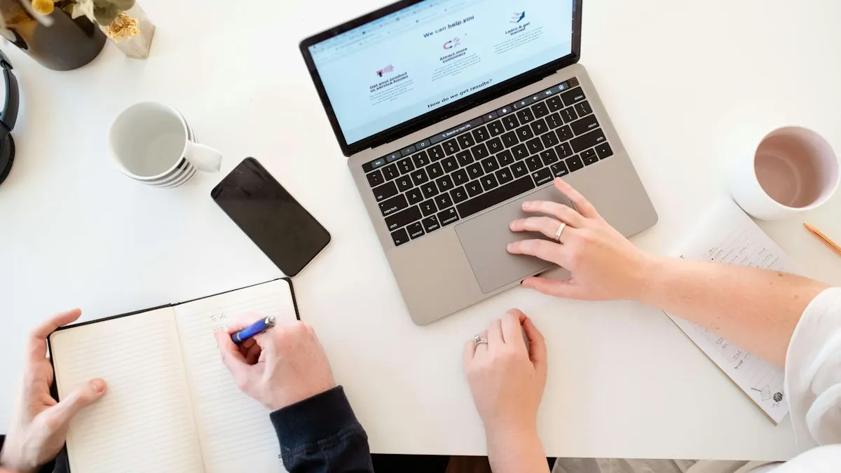 Digital marketer working on a laptop at a white desk with notes beside the keyboard