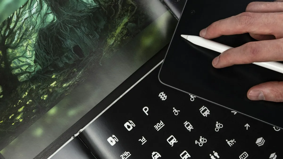 Designer using a stylus on a tablet beside a printed sheet of simple icon designs