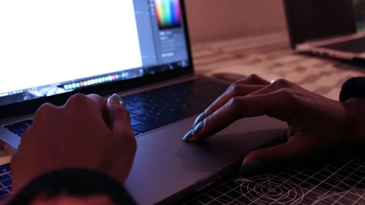 Designer's hands on a laptop keyboard with a colour palette open in the design software