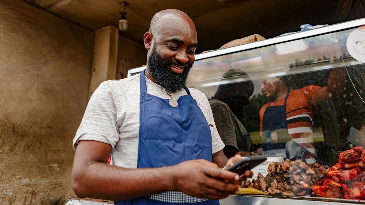 Shop owner in an apron checking a social media post on his phone behind his food counter