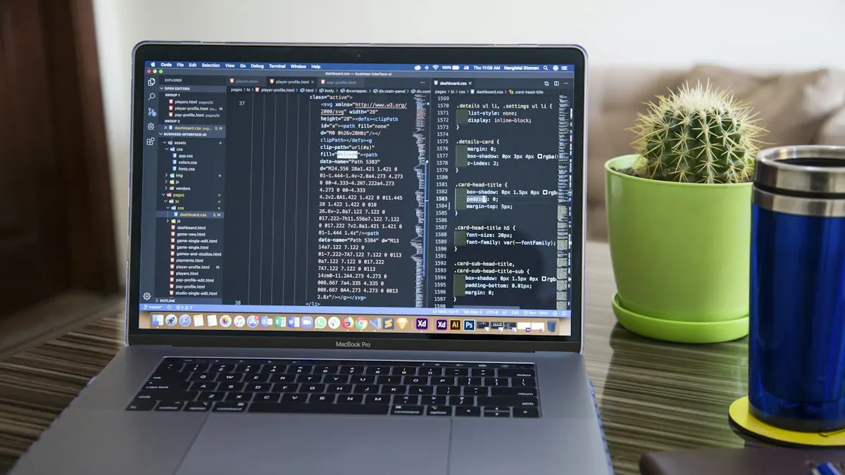 Laptop showing lines of website code on a desk with a cactus and a blue mug