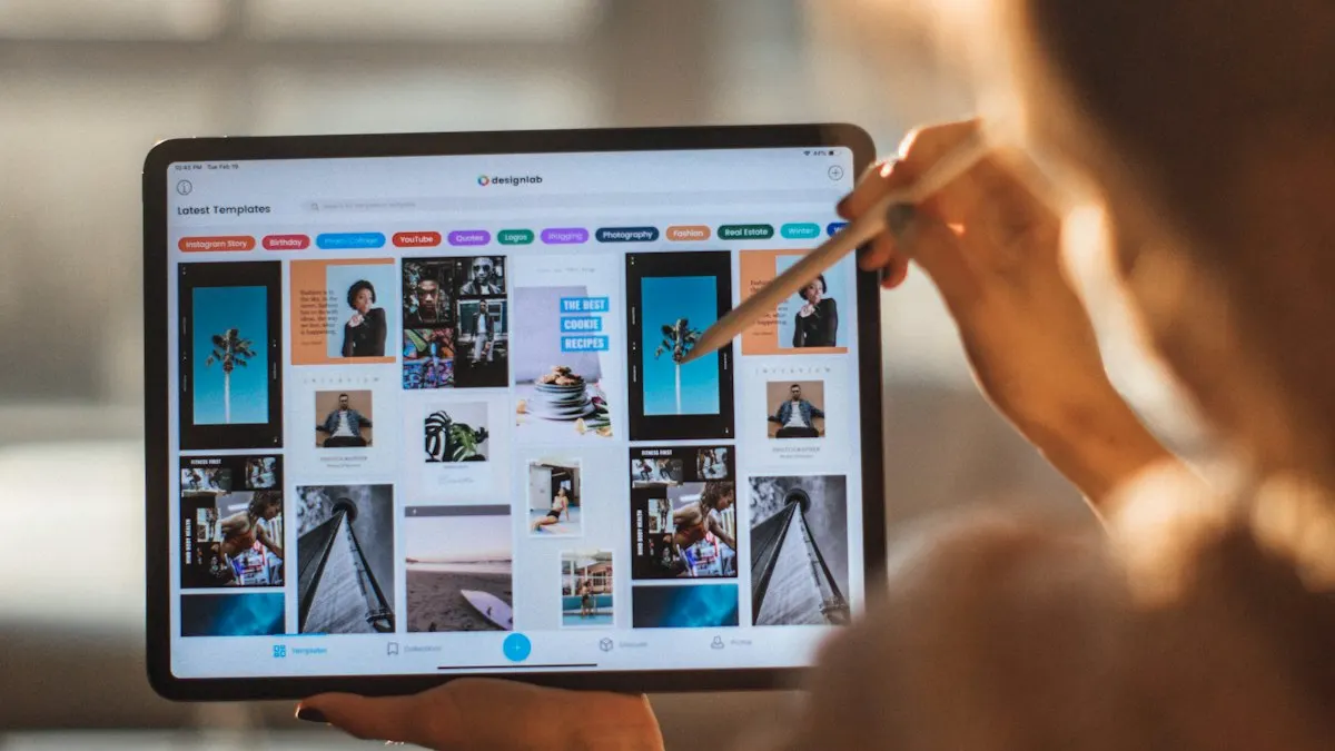 Designer using a stylus on a tablet with a grid of photos for a campaign layout