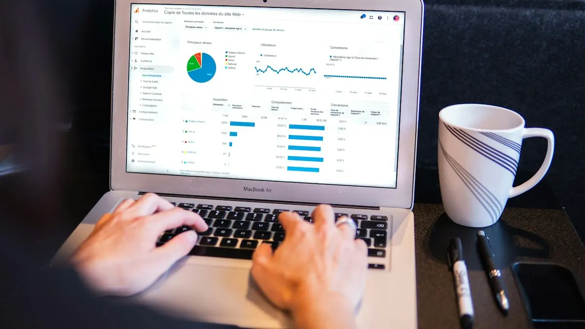 Hands typing on a laptop showing a marketing dashboard with charts next to a white mug