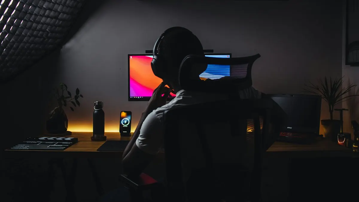 YouTube video editor wearing headphones at a desk editing a video on a computer in a dim room