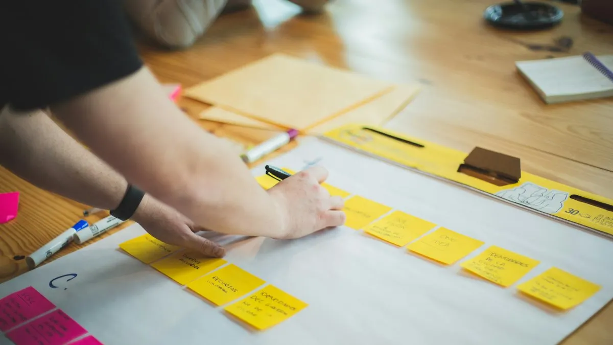 Person writing a campaign plan on yellow sticky notes laid across a wooden table