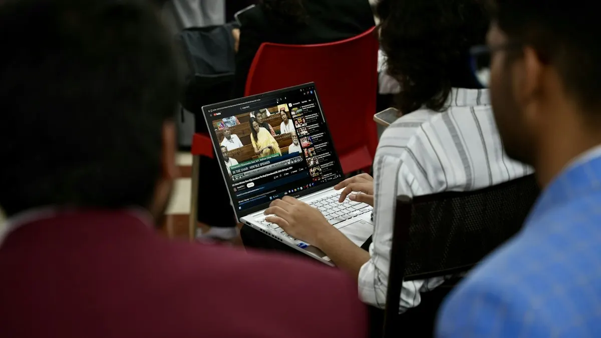 Group of young students in a classroom working together on a laptop
