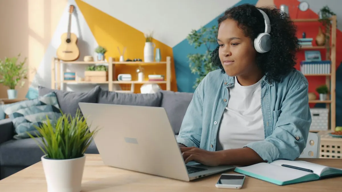 Young woman wearing headphones learning video editing on a laptop at home