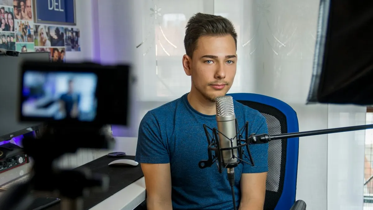 Young creator sitting at a desk with a microphone in front of a camera recording a video
